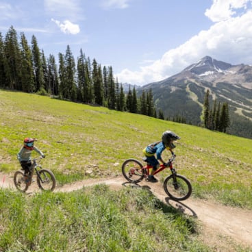 Kids mountain biking with Lone Peak in the background // Youth Bike Camps in Big Sky Montana