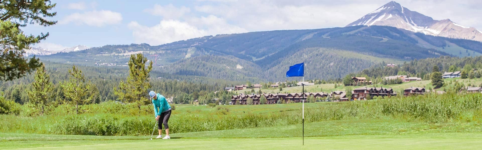 Woman putting with Lone Peak in the background