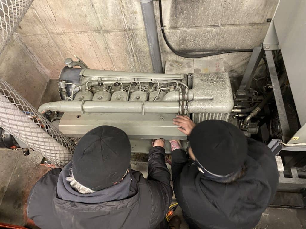Two people looking over an auxiliary engine