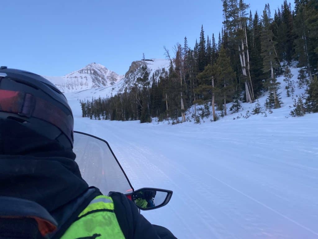 View from a snowmobile with Lone Peak in the distance