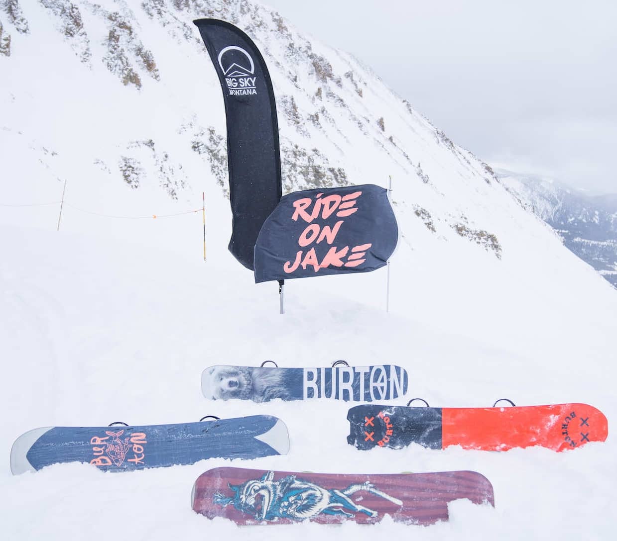 Snowboards and a flag in the snow