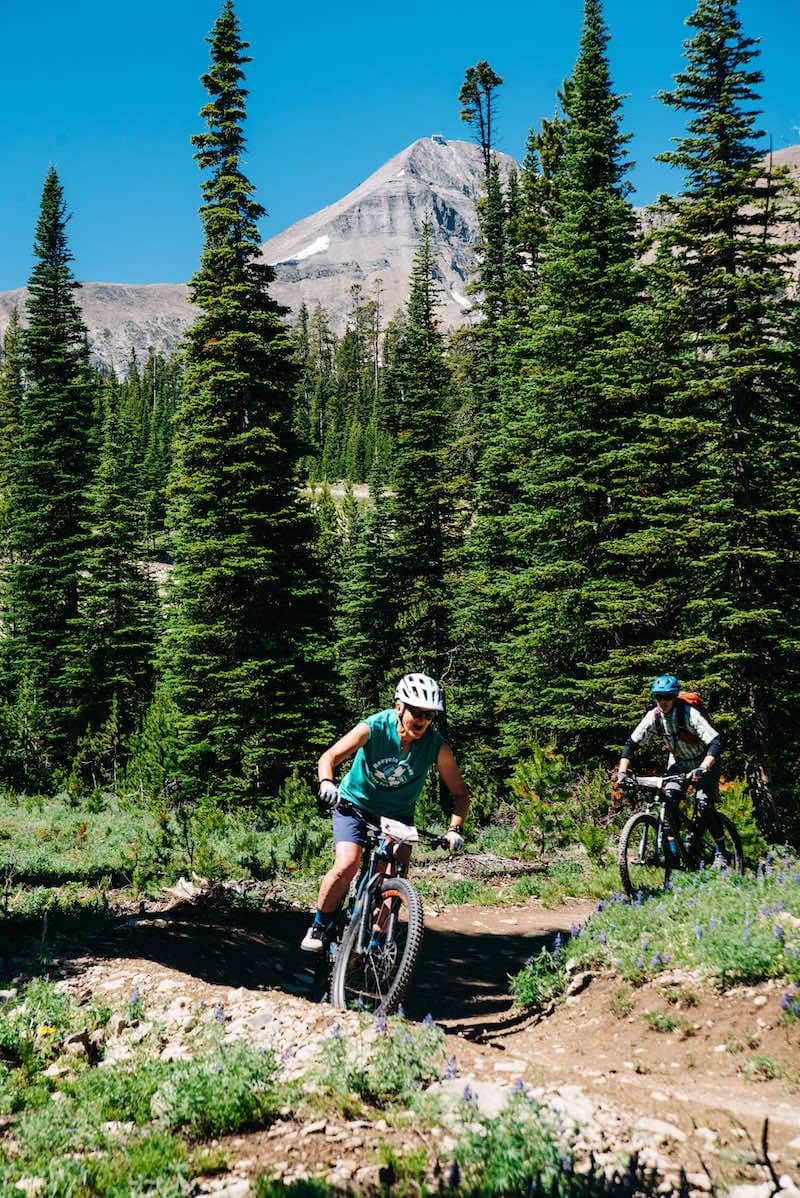 Women riding mountain bikes in front of Lone Peak