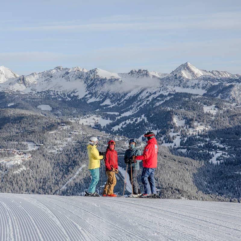 Group of skiers with an instructor standing on a groomed run