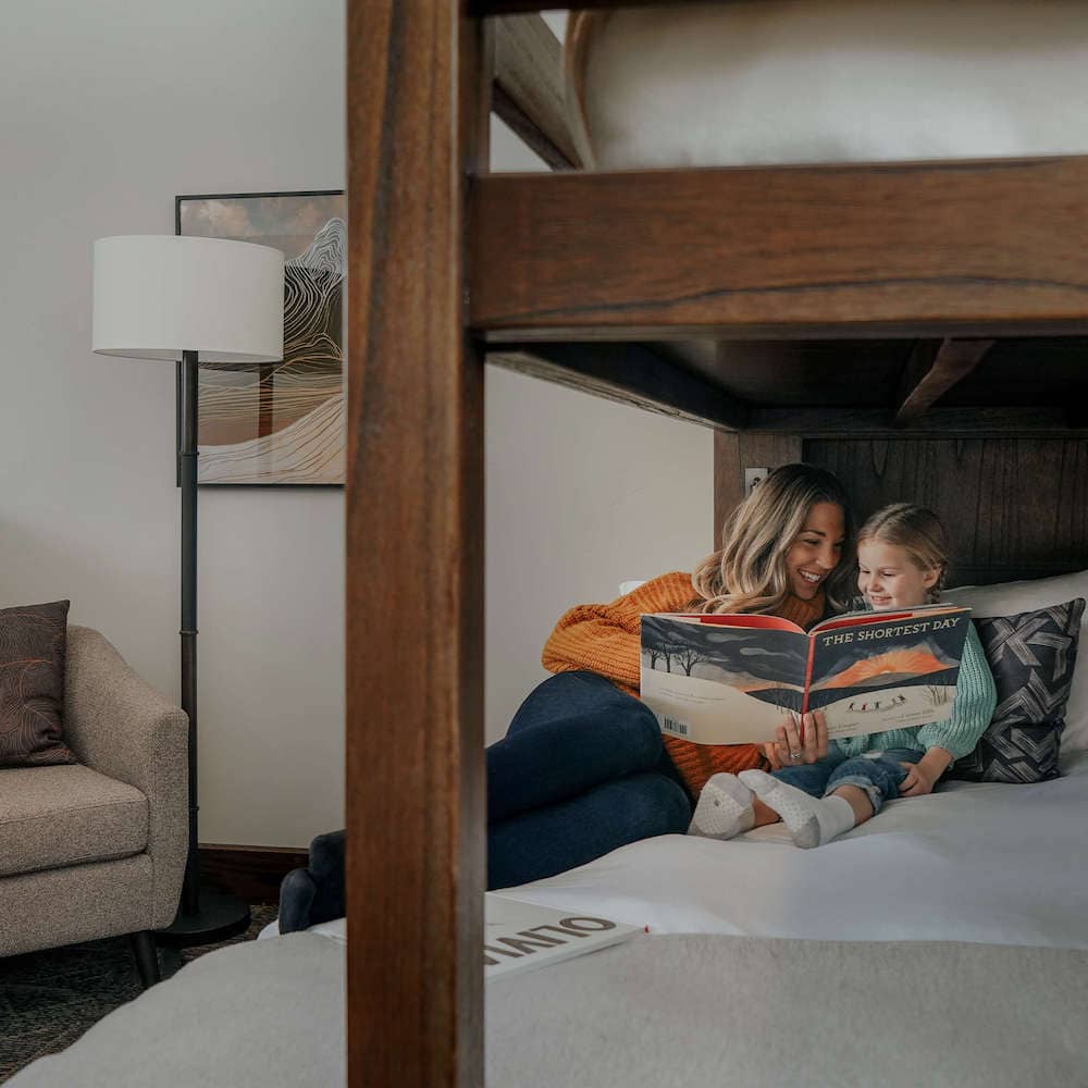 Mom and daughter reading in a bunk bed